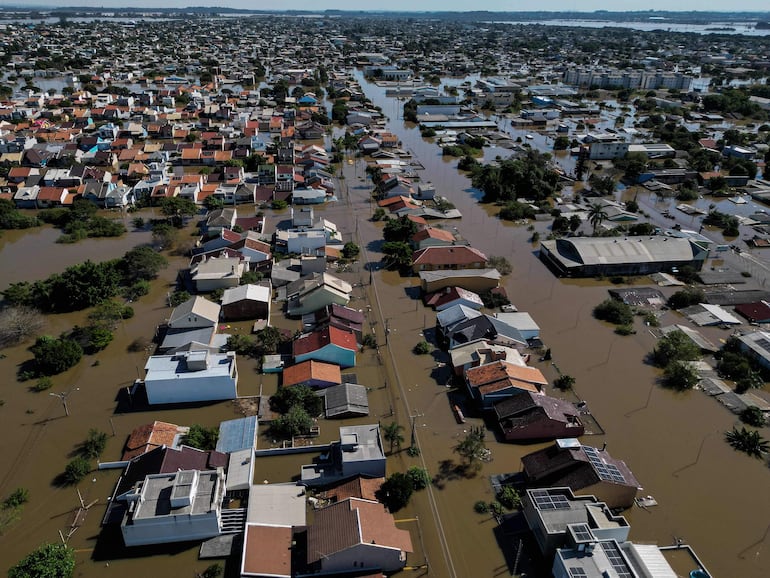 Aerial view of a flooded area of Canoas, a municipality north of Porto Alegre, Brazil, taken on May 7, 2024, after torrential rains devastated parts of the southern state of Rio Grande do Sul. Since the unprecedented deluge started last week, at least 90 people have died, 131 are missing and more than 150,000 were ejected from their homes by floods and mudslides in Rio Grande do Sul State, authorities said. (Photo by Nelson ALMEIDA / AFP)