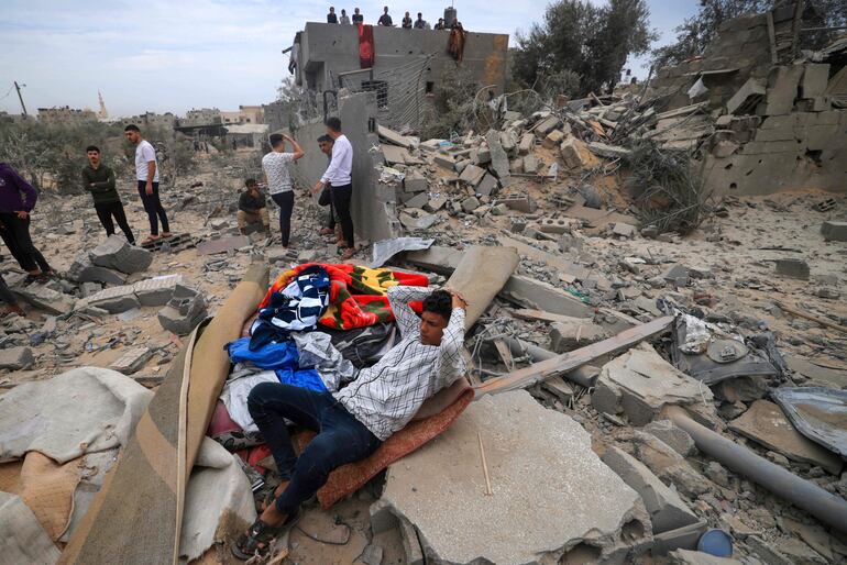 Un hombre descansa entre los escombros de un edificio destruido por un bombardeo israelí en Jan yunis, en el sur de la Franja de Gaza, este domingo.