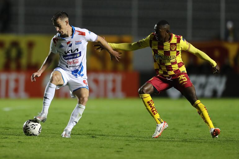 El argentino Juan Alfaro (i), futbolista de Nacional, domina el balón frente a Renny Jaramillo, jugador de Aucas, en un partido de la Fase 1 de la Copa Libertadores 2024 en el estadio Gonzalo Pozo Ripalda, en Quito, Ecuador.