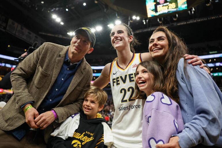 Ashton Kutcher y Mila Kunis con sus hijos Wyatt y Dimitri posan con la jugadora de Indiana Fever, Caitlin Clark, en el Crypto.com Arena de Los Ángeles, California.