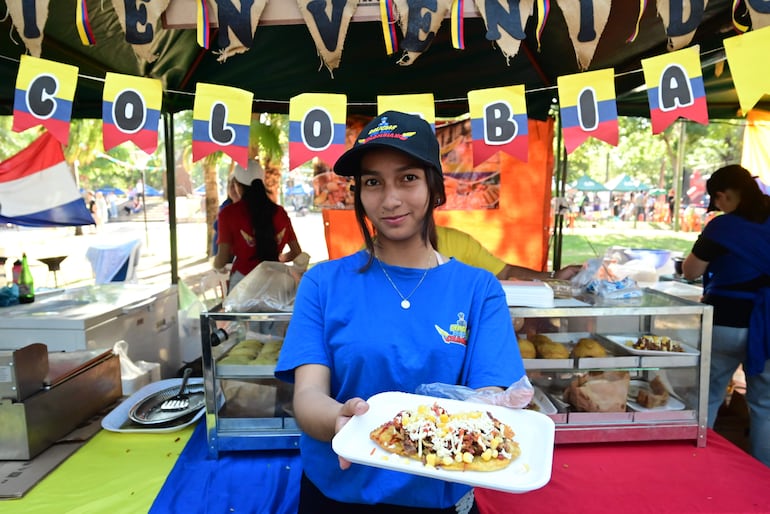 Una joven colombiana muestra un plato típico de su país que fue muy pedido por los presentes.