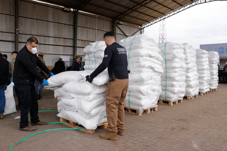 Agentes de la Senad y funcionarios del Ministerio Público verifican los productos contaminados con cocaína.