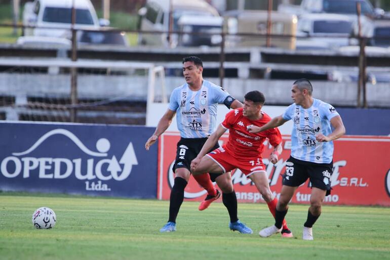 Mathías Martínez (Nacional), ante la marca de Patricio Coronel y Miguel Paniagua (Guaireña).