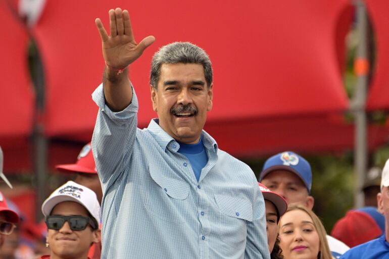 TOPSHOT - Venezuelan President and presidential candidate Nicolas Maduro greets supporters at his campaign closing rally in Caracas on July 25, 2024, ahead of Sunday's presidential election. Venezuelan President Nicolas Maduro and his main rival in the July 28 presidential elections, opposition candidate Edmundo Gonzalez Urrutia, close their campaigns on Thursday amidst Maduro's warnings of a "bloodbath" or a military insurrection if he is defeated. (Photo by Yuri CORTEZ / AFP)