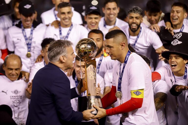 Javier Díaz de Vivar, vicepresidente de la Asociación Paraguaya de Fútbol (APF), entrega el trofeo del Torneo Apertura 2022 a Óscar Cardozo (d), futbolista de Libertad, en el estadio La Huerta, en Asunción.