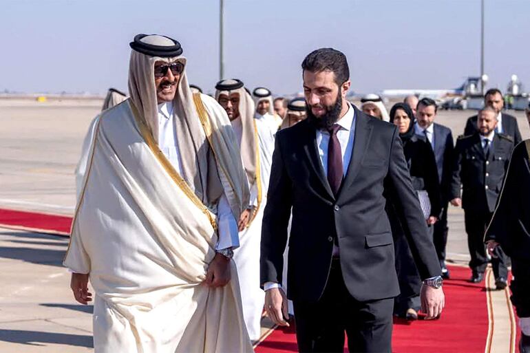 El Emir Sheikh Tamim bin Hamad Al-Thani (i) de Catar  es recibido por el presidente designado de Siria, Ahmed al-Sharaa.