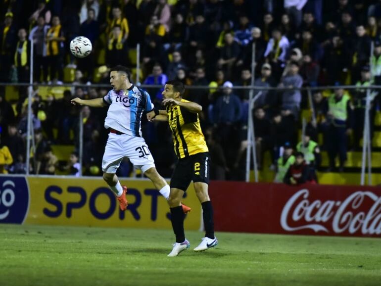 Enso González (i), futbolista de Libertad, disputa el balón con Raúl Cáceres, jugador de Guaraní, en un partido por el torneo Clausura 2023 del fútbol paraguayo en el estadio Rogelio Silvino Livieres, en Asunción.