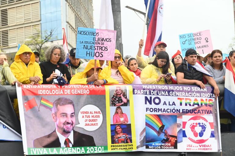 En la foto, se observa a algunos de los asistentes a la marcha contra el Plan de Transformación Educativa, con carteles en contra del presidente Mario Abdo Benítez por ser "protector de la ideología de género".m