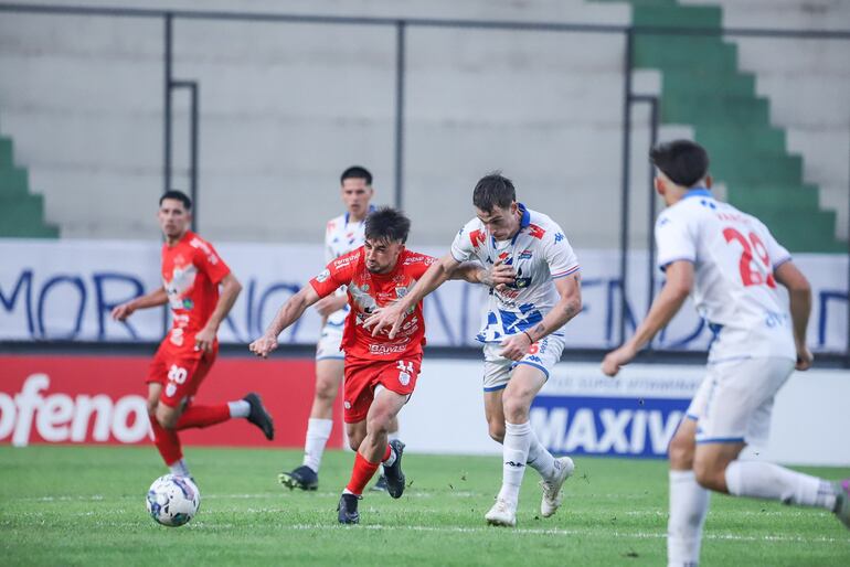 Sergio Fretes (i), jugador de Sportivo Ameliano, pelea por el balón en el partido frente a Nacional por la tercera fecha del torneo Clausura 2024 del fútbol paraguayo en el estadio Arsenio Erico, en Asunción, Paraguay.