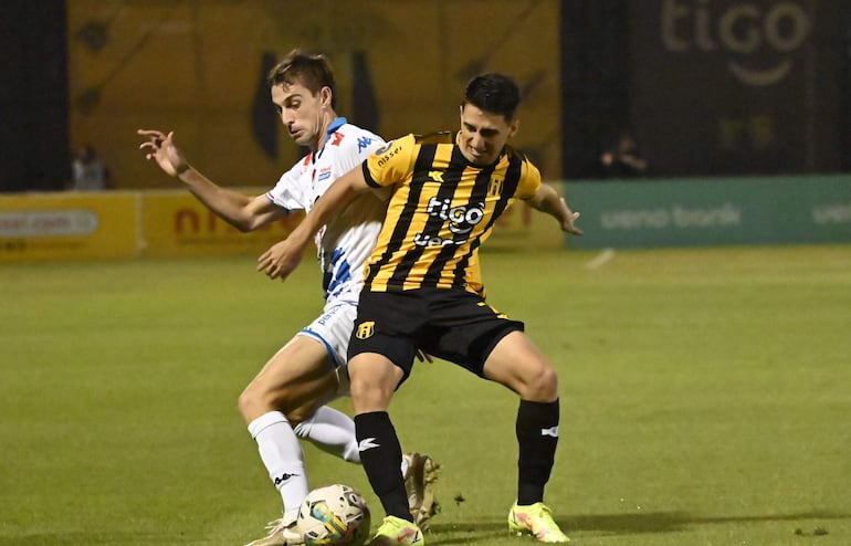 Juan Fernando Alfaro, volante de Guaraní, pelea por la tenencia de la pelota con el volante aurinegro Agustín Manzur