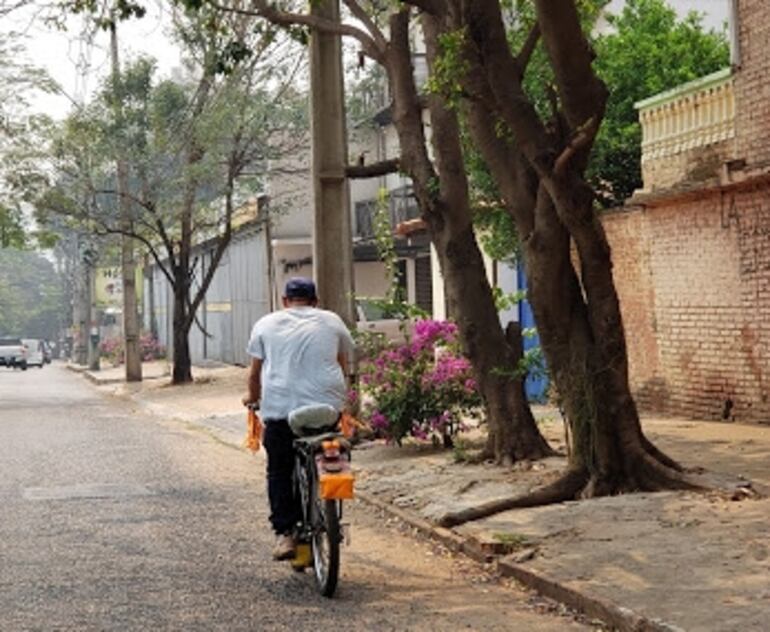 Un trabajador circula en bicicleta por la calle Denis Roa, en el barrio Herrera de Asunción.