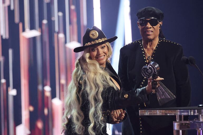 Beyoncé recibiendo el Premio Innovación de manos de Stevie Wonder. Ella optó por un estilo cowboy con un atuendo vintage de Versace.
(Amy Sussman/Getty Images/AFP)
