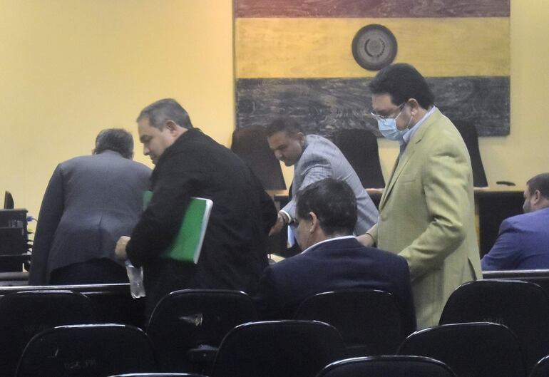 El diputado Rubén Roussillón (con carpeta en verde) y José Ortiz, expresidente de Conajzar, se presentaron esta mañana en la audiencia preliminar ante el juez Humberto Otazú. La diligencia continua mañana.