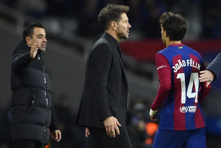 El delantero portugués de Barcelona #14 Joao Felix pasa junto al entrenador argentino del Atlético de Madrid, Diego Simeone, mientras el entrenador español del Barcelona, ​​Xavi (i), espera estrecharle la mano después de ser sustituido durante el partido de fútbol de la liga española entre el FC Barcelona y el Club Atlético de Madrid en el Estadi Olimpic. Lluis Companys en Barcelona el 3 de diciembre de 2023.