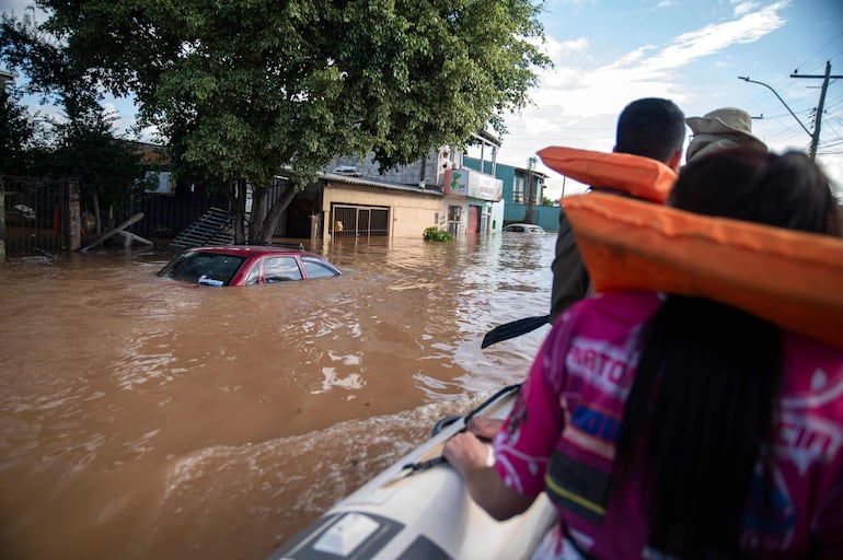 En un bote inflable, unas personas salen de Eldorado do Sul, en Rio Grande do Sul.