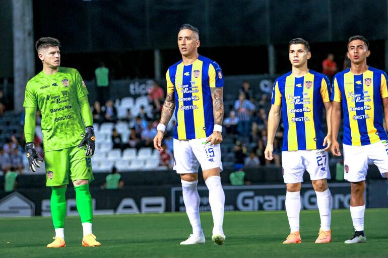 Alfredo Aguilar (I), Lucas Barrios, Julio Báez y Ángel González (d), jkugadores de Sportivo Luqueño, en el ingreso al campo de juego para el partido contra Libertad por la novena jornada del torneo Clausura 2023 del fútbol paraguayo en el estadio La Huerta, en Asunción.