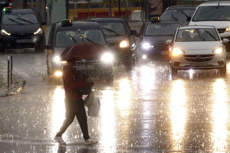 Una persona camina bajo una fuerte lluvia. La llegada de un nuevo temporal con posibilidad de lluvias torrenciales ha vuelto a poner en alerta a España dos semanas después de las catastróficas inundaciones del 29 de octubre, que han dejado ya más de dos centenares de muertos, una treintena de desaparecidos y daños incalculables.