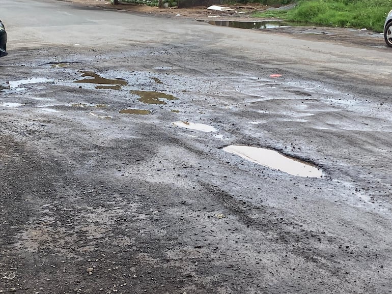 Calle Bernardino Caballero con deterioro de su capa asfáltica y acumulación de agua.