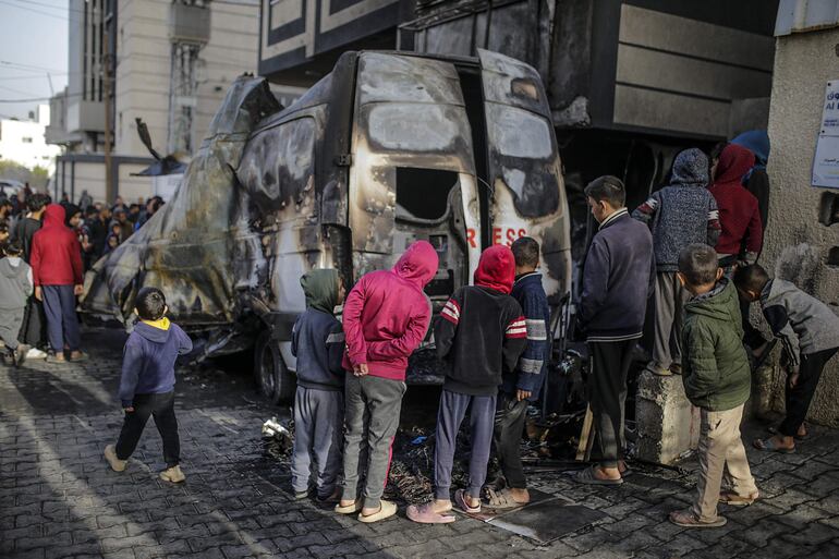 Palestinos inspeccionan un vehículo de prensa destruido cerca del hospital de Al Awda, después de un ataque aéreo israelí en el campamento de refugiados de Al Nuseirat, en la Franja de Gaza este jueves. Según la Oficina de Medios del Gobierno (GMO) en Gaza, cinco periodistas del canal de televisión por satélite 'Al-Quds Today' fueron asesinados después de que un ataque aéreo israelí de la noche a la mañana golpeara su vehículo en el campamento de Al Nuseirat, en el centro de Gaza. El número de periodistas asesinados en 2024 batió un dramático récord, con 179 muertes, entre las cuales tres de cada cuatro ocurrieron en zonas de conflicto, según la oenegé PEC (Campaña por un Emblema de Prensa).