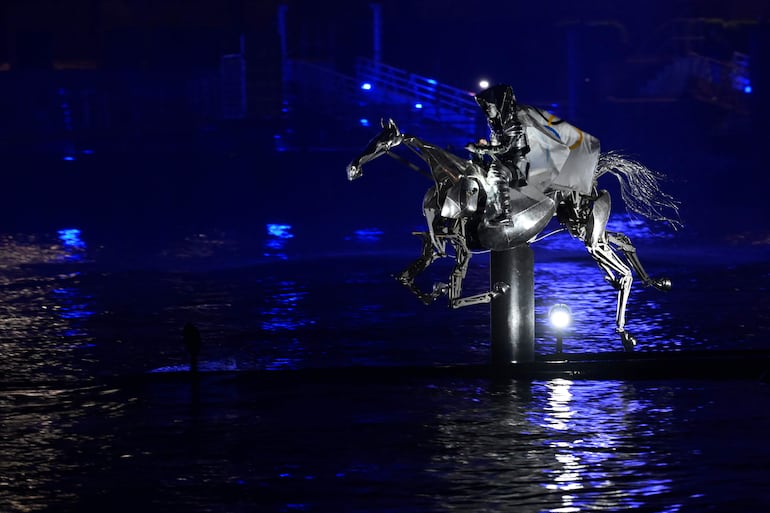 Un caballo metálico cabalga sobre el río Sena envuelto en la bandera olímpica. 