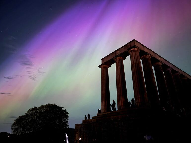 Esta fotografía muestra la aurora boreal durante una tormenta solar sobre el Monumento Nacional de Escocia en Edimburgo.