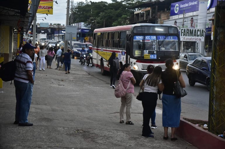 Gran cantidad de pasajeros esperando el bus en medio de las reguladas.