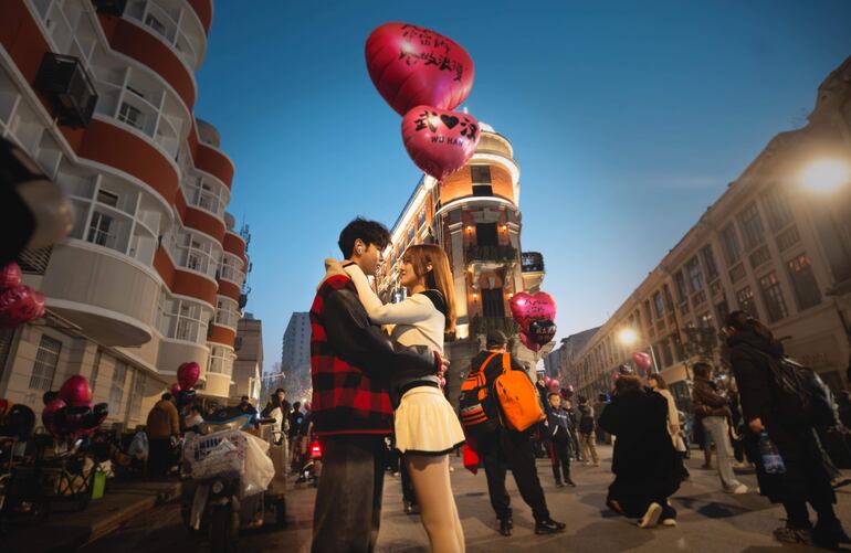 Una pareja se mira frente a Bagong House, un lugar popular entre los jóvenes, en Wuhan, provincia de Hubei, China, en enero de este año. A medida que se acerca el quinto aniversario del confinamiento de 76 días de Wuhan, el 23 de enero de 2025, los orígenes de COVID-19 siguen sin resolverse, y la Organización Mundial de la Salud (OMS) sigue instando a China a que facilite más datos, mientras Pekín insiste en que ha revelado toda la información disponible. La vida en la ciudad de más de 11 millones de habitantes ha vuelto en gran medida a la normalidad, pero los recuerdos de la pandemia persisten para muchos residentes que recuerdan la incertidumbre de los primeros días, la escasez de alimentos y la lucha por encontrar camas de hospital. Los primeros casos surgieron en diciembre de 2019, lo que llevó a un estrictoconfinamiento en Wuhan el 23 de enero de 2020, a medida que aumentaban las infecciones en todo el mundo. La OMS calcula cerca de 800 millones de infecciones y 7 millones de muertes, aunque las cifras varían. El debate sobre los orígenes de COVID-19 continúa, con algunos científicos sospechando de la transmisión de animal a humano, mientras que otros apuntan a un posible incidente relacionado con un laboratorio. 