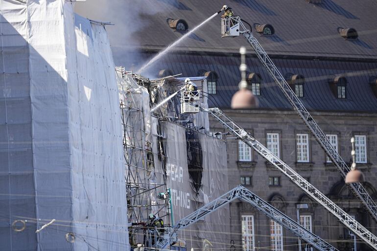 Los bomberos luchan contra el incendio en el edificio de la antigua Bolsa de valores (Boersen), en Copenhague, Dinamarca. Un violento incendio estalló en el edificio que está en renovación en la mañana del 16 de abril. El edificio fue construido en la década de 1620 como edificio comercial por el rey Cristián IV y está situado junto al parlamento danés. 