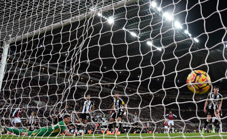 West Ham United's English defender #29 Aaron Wan-Bissaka (L) watches as his shot beats Newcastle United's English goalkeeper #22 Nick Pope for their second goal during the English Premier League football match between Newcastle United and West Ham United at St James' Park in Newcastle-upon-Tyne, north east England on November 25, 2024. (Photo by Paul ELLIS / AFP) / RESTRICTED TO EDITORIAL USE. No use with unauthorized audio, video, data, fixture lists, club/league logos or 'live' services. Online in-match use limited to 120 images. An additional 40 images may be used in extra time. No video emulation. Social media in-match use limited to 120 images. An additional 40 images may be used in extra time. No use in betting publications, games or single club/league/player publications. / 