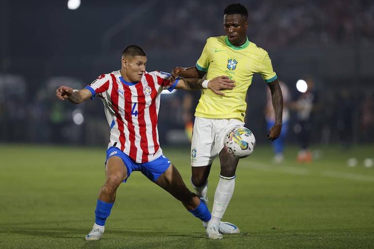 Juan José Cáceres (i), jugador de la selección de Paraguay, pelea por el balón en el partido frente a Brasil por las Eliminatorias Sudamericanas 2026 en el estadio Defensores del Chaco, en Asunción, Paraguay.