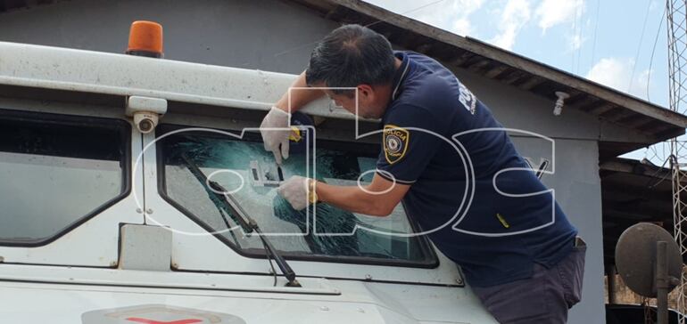 Dos impactos de bala son inspeccionadas por un agente de Policía. Se trata balazos en el parabrisas.