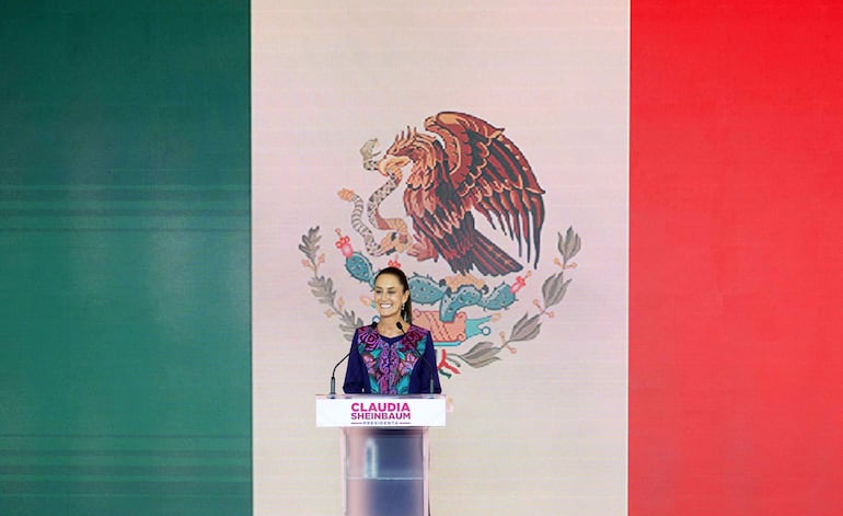 La presidenta electa Claudia Sheinbaum y en el fondo una bandera de México. 