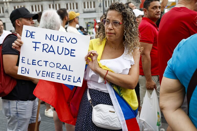 MADRID , 29/07/2024.- Una mujer sostiene una pancarta en la manifestación convocada por la oposición venezolana un día después de las elecciones en el país, este lunes en Madrid. EFE/ J.P.Gandul
