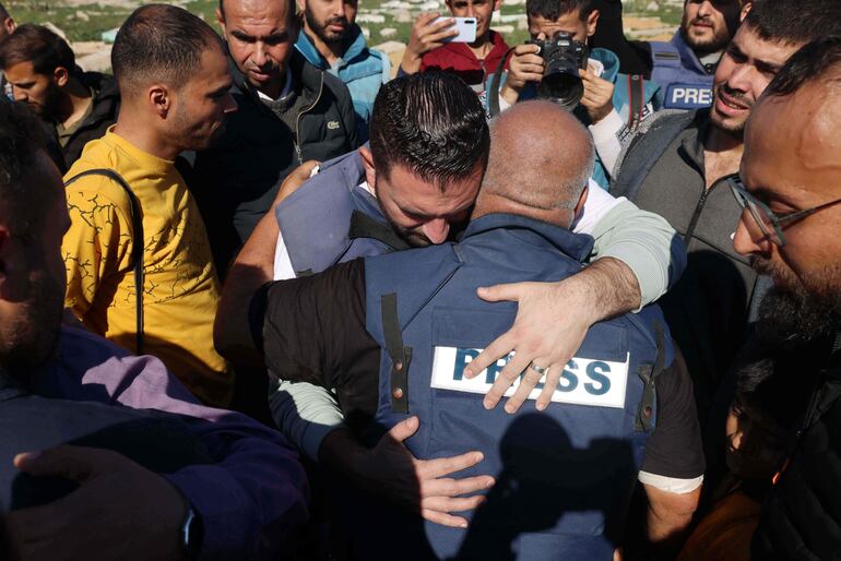 Al Jazeera's bureau chief in Gaza, Wael Al-Dahdouh (C) is comforted during the funeral of his son Hamza Wael Dahdouh, a journalist with the Al Jazeera television network, who was killed in a reported Israeli air strike, in Rafah in the Gaza Strip on January 7, 2024. Dahdouh, who was himself wounded in the arm, lost his wife and two other children in Israeli bombardment in the initial weeks of the war. (Photo by AFP)