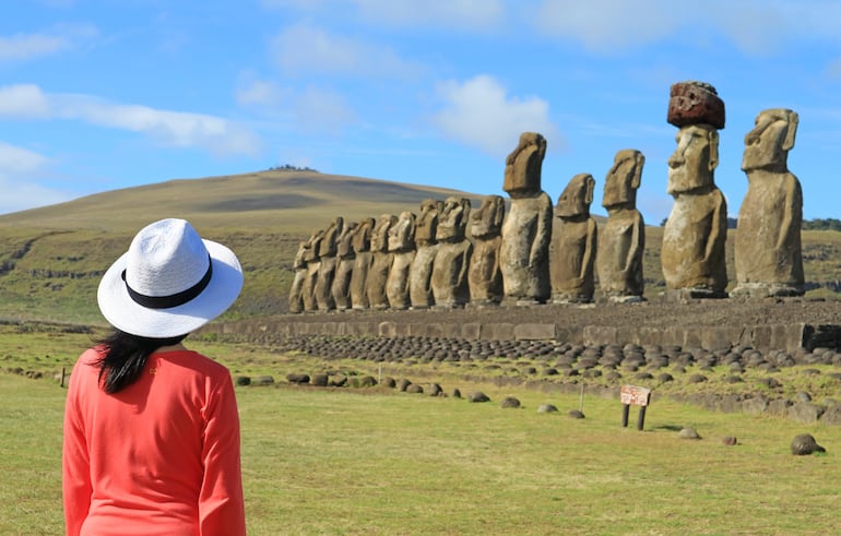 Mujer visitando las icónicas quince estatuas de Ahu Tongariki en Isla de Pascua, Chile.