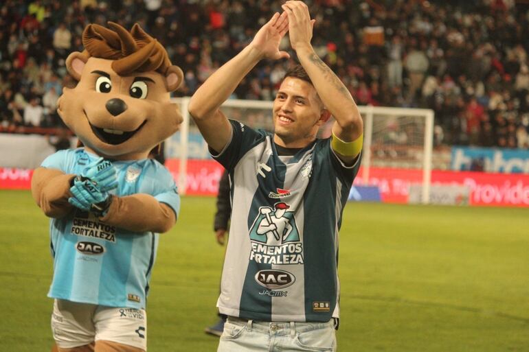 Fernando Ovelar, 19 años, futbolista paraguayo del Pachuca. Al lado, la mascota del club.