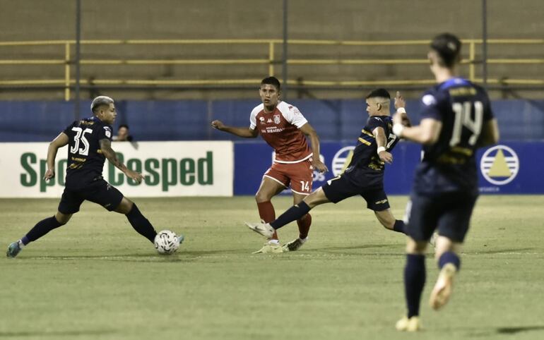 Alexis Rodas (c), de General Caballero, disputa el balón ante Pedro Delvalle (i) y Pedro Arce (d), de Trinidense.