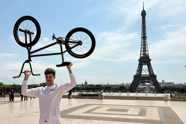 El portador de la llama olímpica, el ciclista francés Matthias Dandois, posa para los fotógrafos tras su relevo en la plaza de Trocadero en París, Francia.