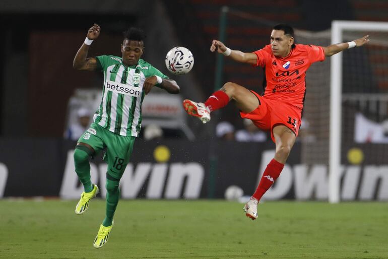 Édier Ocampo (i) de Atlético Nacional disputa el balón con Gustavo Caballero de Nacional este miércoles, en un partido de segunda fase de la Copa Libertadores entre Atlético Nacional y Club Nacional en el estadio Atanasio Girardot en Medellín (Colombia).