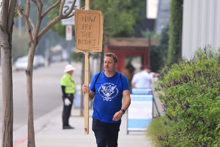 Hollywood (United States), 25/09/2023.- US screenwriter Travis Adam Wright, supporting the Screen Actors Guild, walks with a homemade sign in front of Netflix in Hollywood, California, USA, 25 September 2023. The Writers Guild of America (WGA) reached a tentative agreement to end the writers strike in Los Angeles. EFE/EPA/DAVID SWANSON
