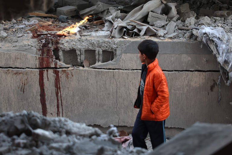 Un niño observa rastros de sangre en el sitio de un bombardeo israelí en Jan Yunis, en el sur de la Franja de Gaza.