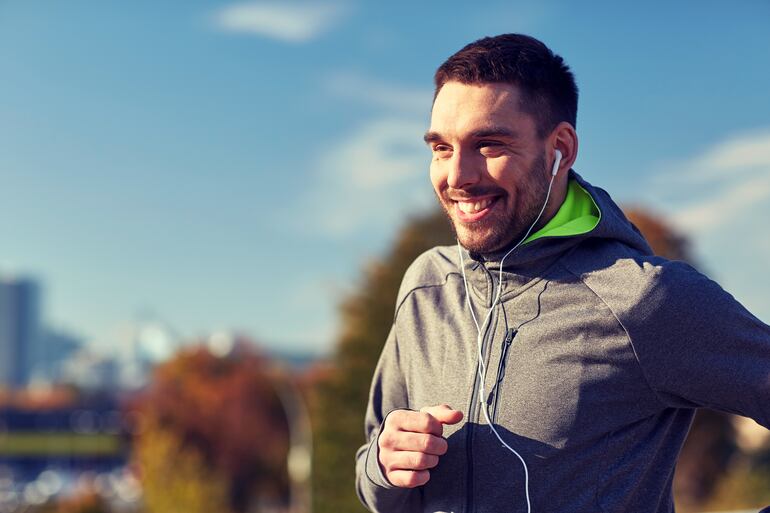 Hombre joven escuchando un podcast mientras hace ejercicio