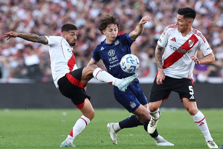 Talleres' Paraguayan midfielder Matias Galarza (C), River Plate's midfielder Manuel Lanzini (L) and midfielder Matias Kranevitter fight for the ball during the Argentine Professional Football League Cup 2024 match between River Plate and Talleres at the Mas Monumental stadium in Buenos Aires on September 29, 2024. (Photo by ALEJANDRO PAGNI / AFP)