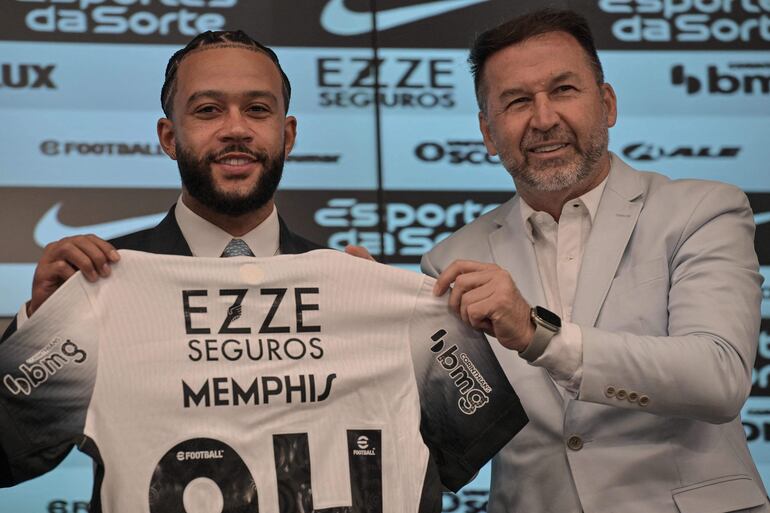 Dutch football forward Memphis Depay poses for a picture with Corinthians President Augusto Melo, during his official presentation at Neo Quimica Arena in Sao Paulo on September 12, 2024. Corinthians of Sao Paulo, which is struggling to stay in the top flight, shook up Brazilian soccer by announcing the signing of Memphis Depay, the '10' of the Netherlands national team, on September 9. (Photo by Nelson ALMEIDA / AFP)