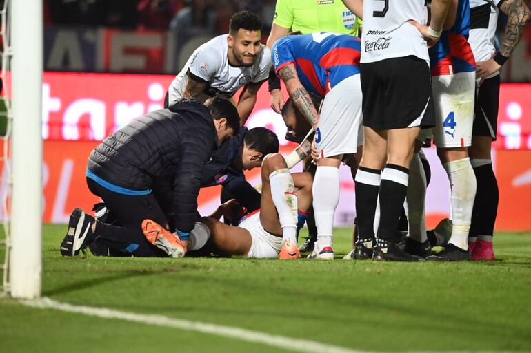 Rodrigo Melgarejo, futbolista de Cerro Porteño, tendido en el suelo después de la falta de Fernando Cardozo, jugador de Olimpia, en el superclásico del fútbol paraguayo por la sexta fecha del torneo Clausura 2023 en el estadio La Nueva Olla, en Asunción.