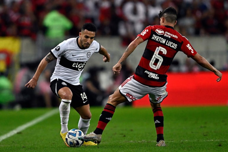 El paraguayo Fernando Cardozo, jugador de Olimpia, domina el balón frente a la marca de Ayrton Lucas, futbolista de Flamengo, por la vuelta de los octavos de final de la Copa Libertadores en el estadio Maracaná, en Río de Janeiro.