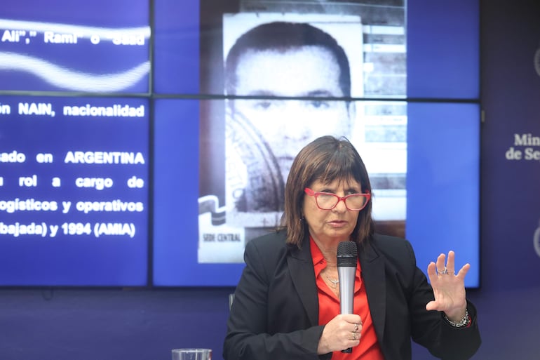 La ministra de Seguridad argentina, Patricia Bullrich, habla durante una rueda de prensa hoy, en Buenos Aires (Argentina).  Presentó el resultado de una investigación internacional sobre el presunto jefe operativo del grupo chií libanés Hezbolá en América Latina cuya imagen se observa al fondo.