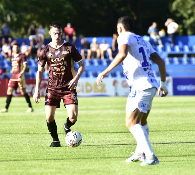 Juan Alfaro, jugador de Nacional, encara la marca de Walter Cabrera, de Ameliano.