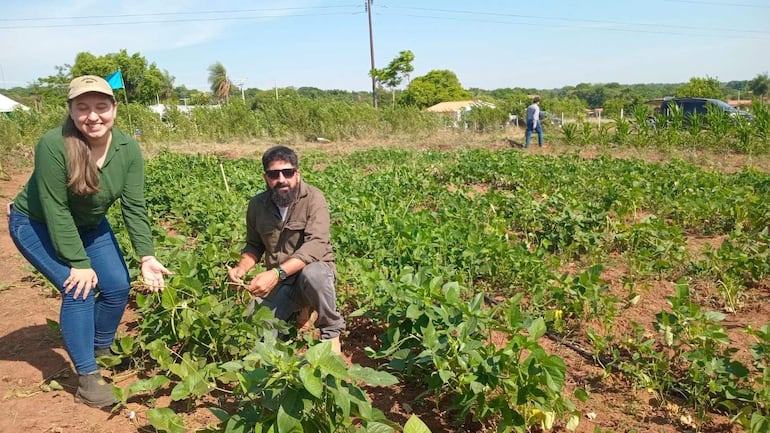 Los estudiantes Nalia Britos y Carlos Recalde muestran el cultivo de poroto, una alternativa productiva para la renta.