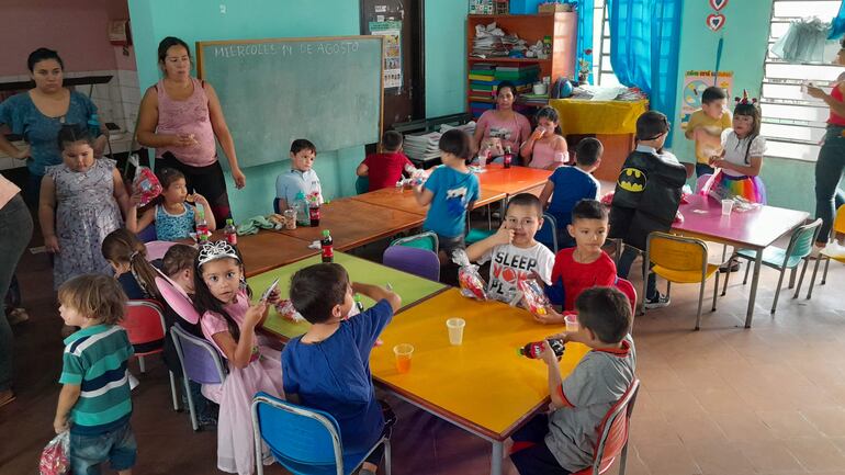 Niños del preescolar disfrutan de una merienda preparada por los padres.